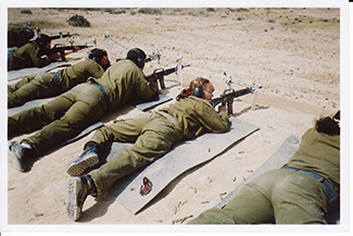 A photograph shows an armed female soldier among a group of soldiers.