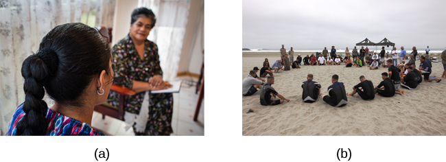 Two photographs are shown. Photograph A depicts two people in conversation. Photograph B depicts a large group of people sitting in a circle on the beach.